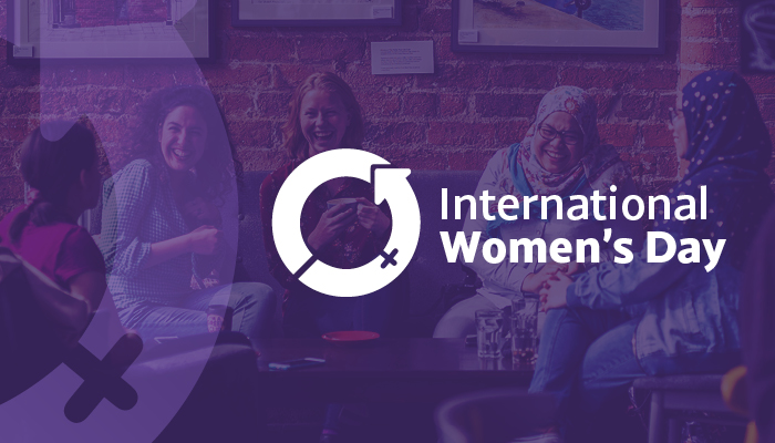 Text reading International Women's Day and the International Women's Day logo over a background image of a group of women.