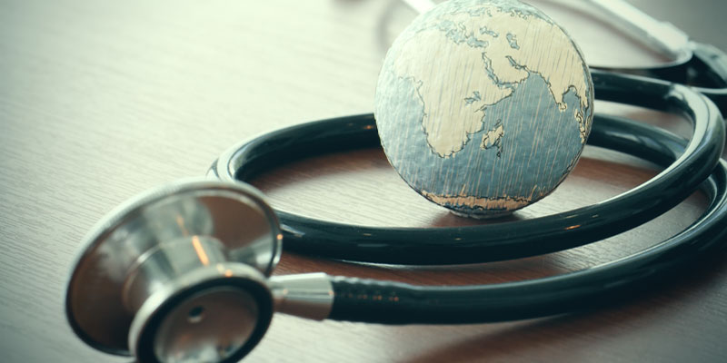 Stethoscope laid out around a small paper globe.