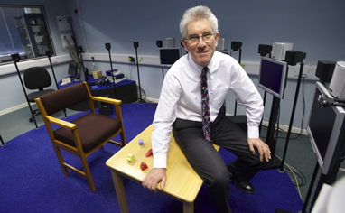 Professor Quentin Summerfield with the semi-circular set-up of speakers which deliver different sounds from different directions to test three-dimensional hearing. Photo by John Houlihan