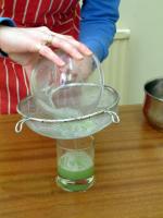 Picture of step 5, sieving the green paste into a glass.