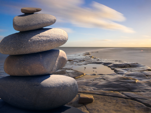A photo of balancing rocks against a beach scene.