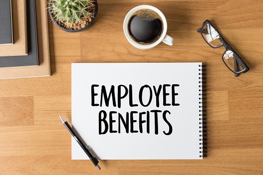 A sign that says employee benefits placed on a desk