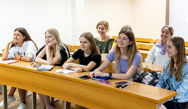 A group of students taking part in the KKNU and CITY College summer school sit in a classroom.