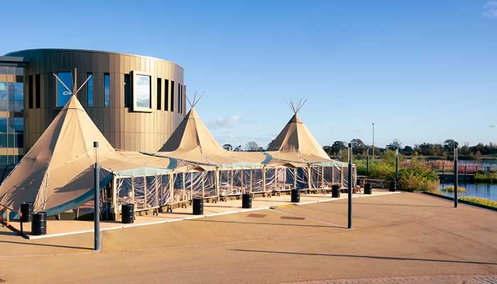 The Piazza building on campus west, with teepees in the foreground.