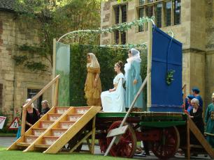 A photograph from the performance of the Mystery Plays featuring 3 actors on top of a wagon acting out a scene from the plays.