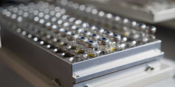 A piece of equipment with glass vials in rows