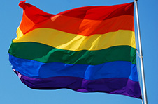 A rainbow coloured flag to represent the LGBTQ+ community flaps in the wind