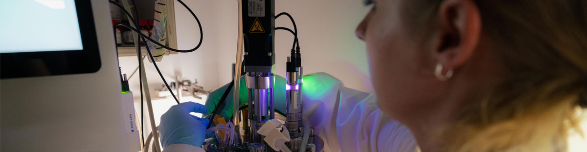 a female researcher loads a piece of microscope equipment