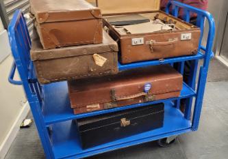 Photograph of an archives trolley containing suitcases of Terry family archives.