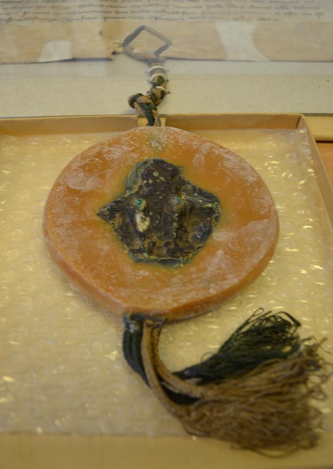 Surviving fragment of the Great Seal of England with green and white silk cords.