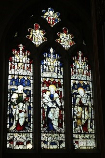 A stained glass window with three panes, showing Hannah and Samuel, St Mary and St Elizabeth. Image Wikimedia Commons