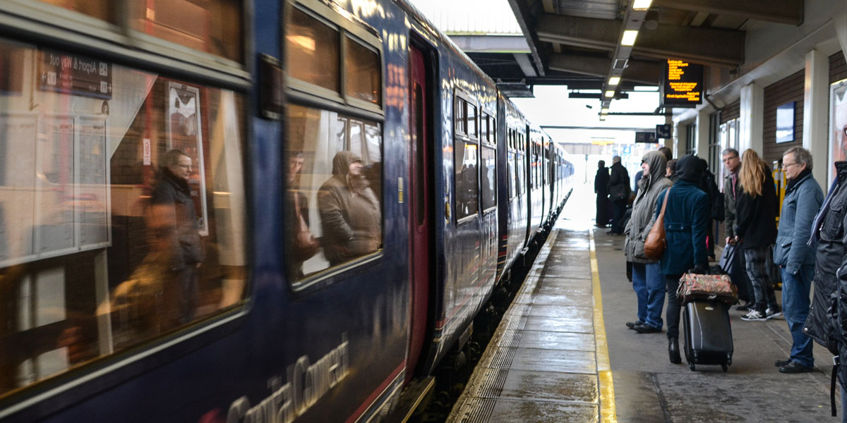 People standing on a rail platform about to board a train