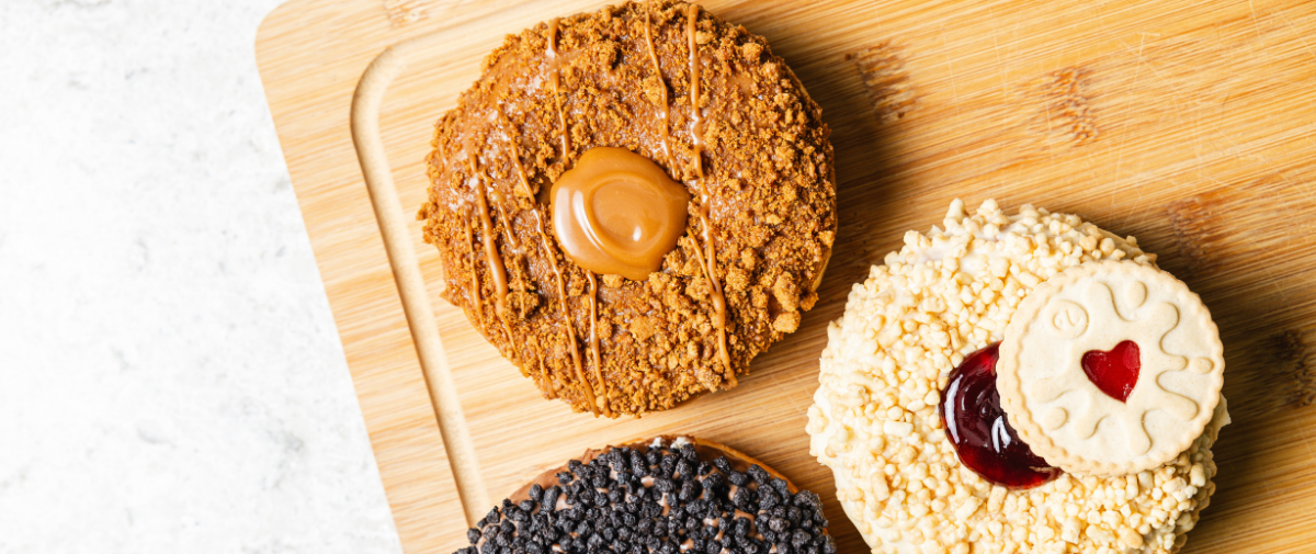 Biscoff doughnut and jammy dodger doughnut on wooden tray