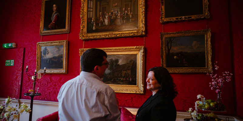 Two academics discussing 18th-century paintings.