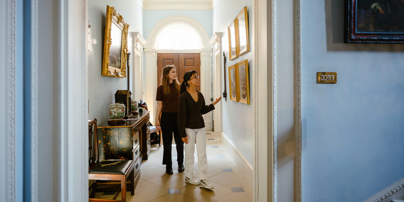Two students looking at art in Fairfax House.