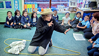Teacher interacting with pupils in a primary school classroom.