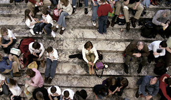 Person sitting alone in a crowd