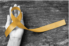Hand holding yellow ribbon