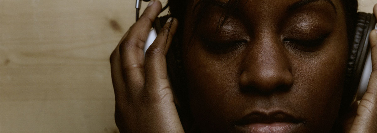 A woman listens to music in her headphones with her eyes closed