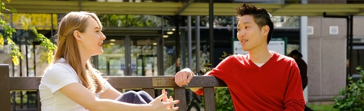 students chatting on bench