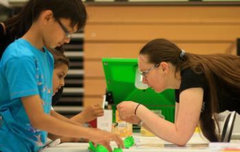 Two children taking part in a maths activity involving frogs, led by one of our PhD students