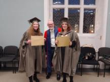 Two of our MA prize winners standing with Kenneth Clarke