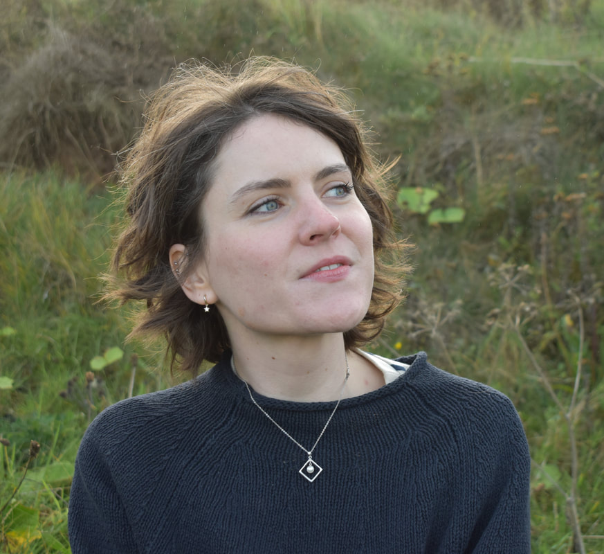 Head profile of Becca Drake with a grassy backdrop