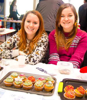 Students selling cake at the Christmas fair