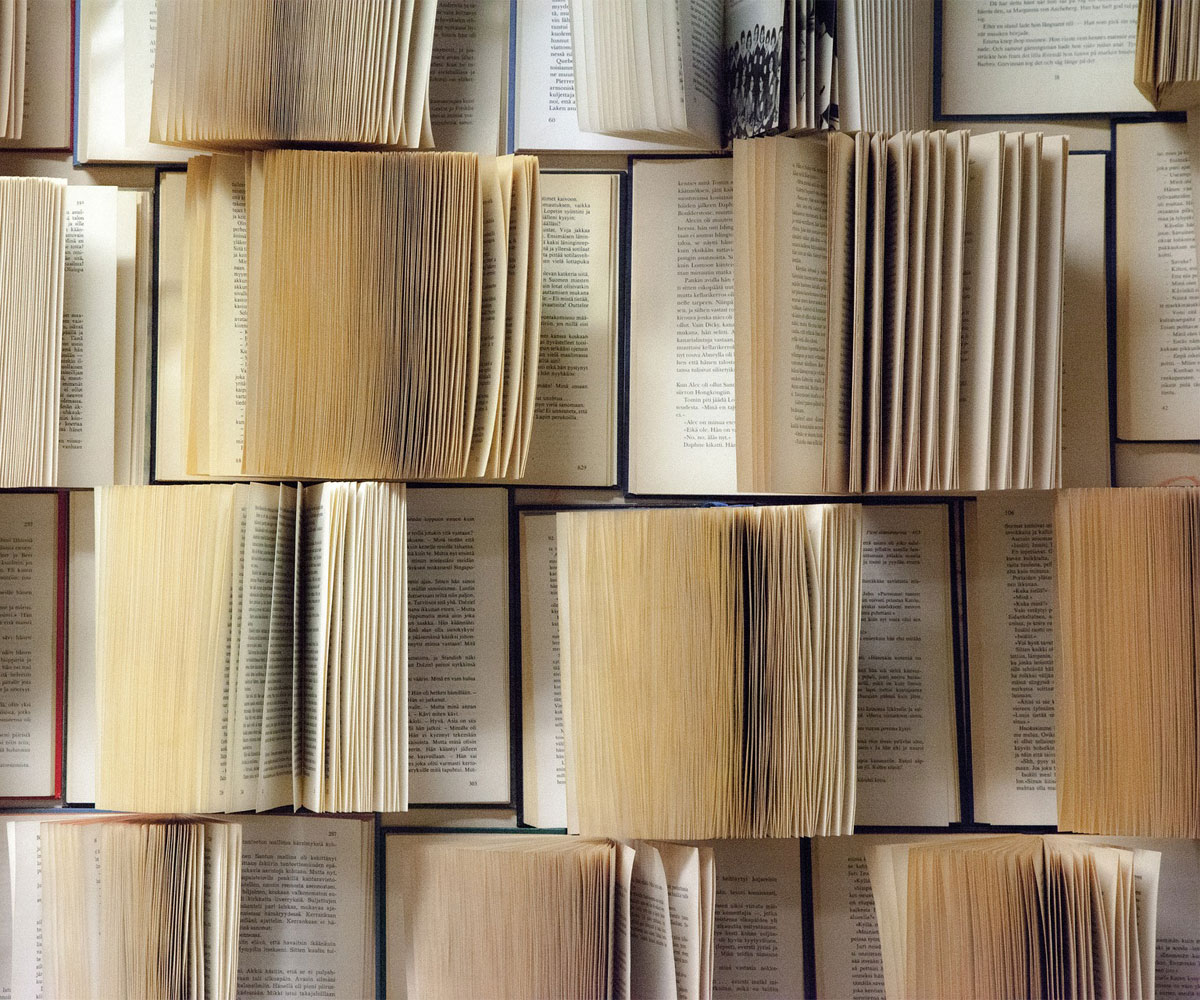 Books laid out in rows with their pages spread.