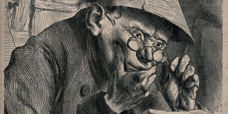 A young man sits reading ledgers at his desk wearing spectacles and an eyeshade. Wood engraving after A. Oberländer. Credit: Wellcome Collection. CC BY