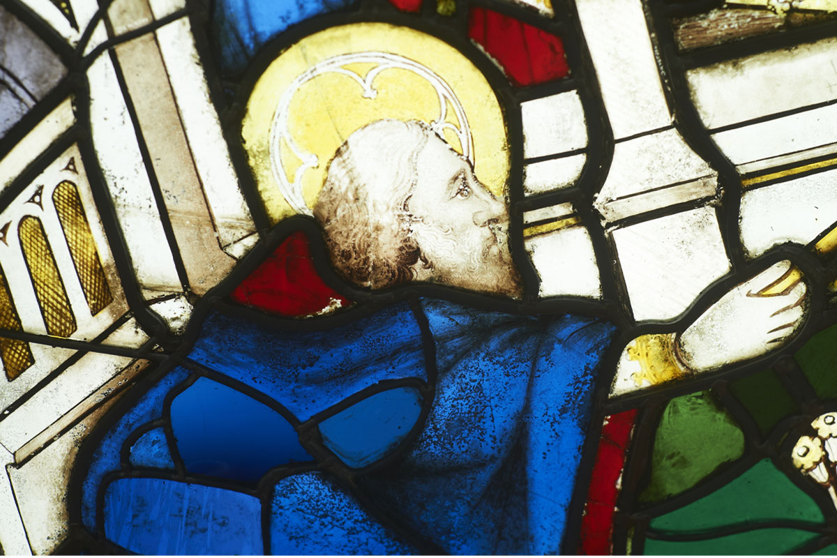 Piece of stained glass from the York Minster window depicting a man kneeling in prayer.