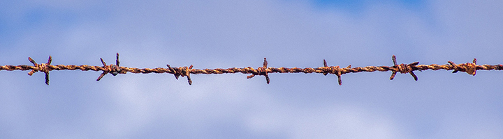 Barbed wire against sky