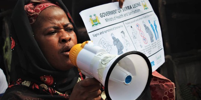 Kaddy Mansaray, Chair of the Funkia Market Women’s Association in Sierra Leone, providing COVID-19 prevention information at the market with a poster and megaphone. Photo: Jonathan Bundu / Trócaire via a CC BY 2.0 licence