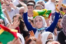 photo of a crowd with a woman in the middle with her arms raised in the air