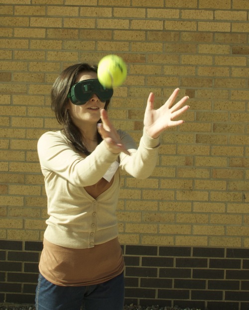 Natalie North trying to catch a ball while wearing displacing prisms, part of Psychology outreach event for the Green Apples programme 