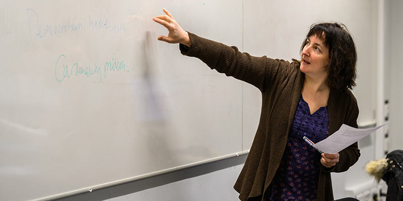 A tutor points at a white board