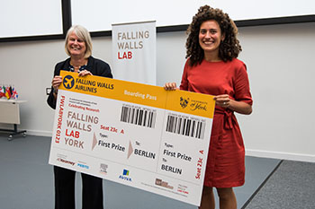 Falling walls winner Jet Sanders receiving an over-sized ticket to Berlin.