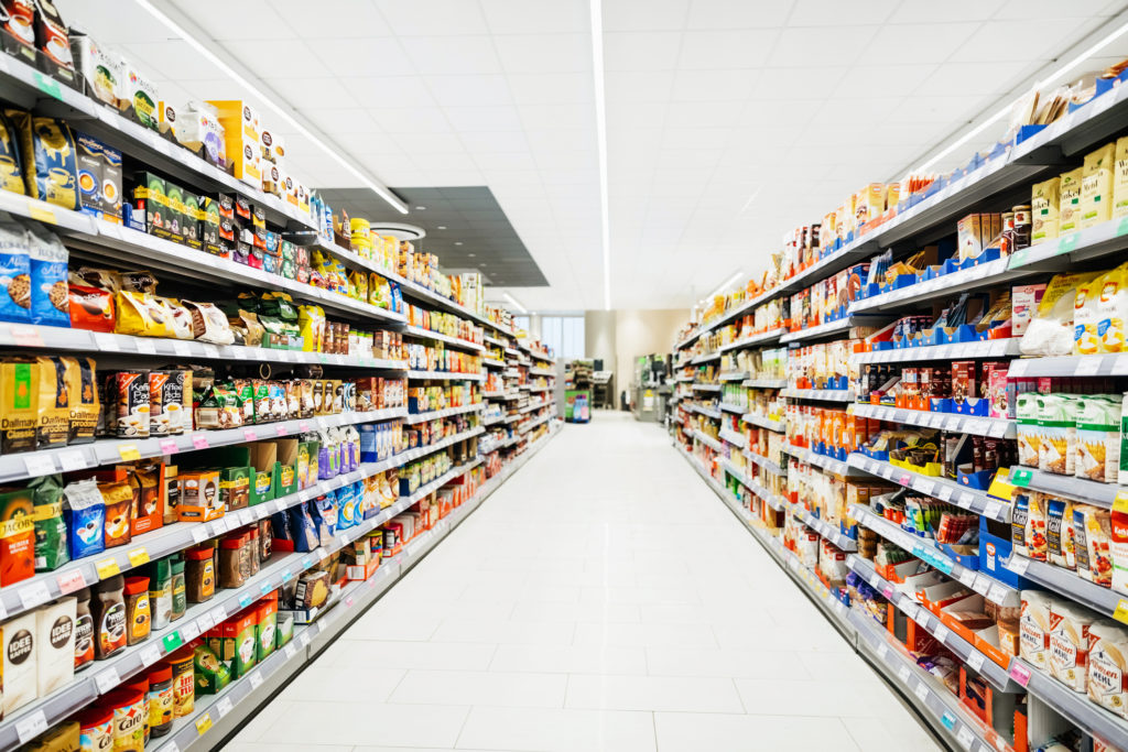 Colourful supermarket aisle with white floor and ceiling. Photo: Tom Werner / Getty Images.