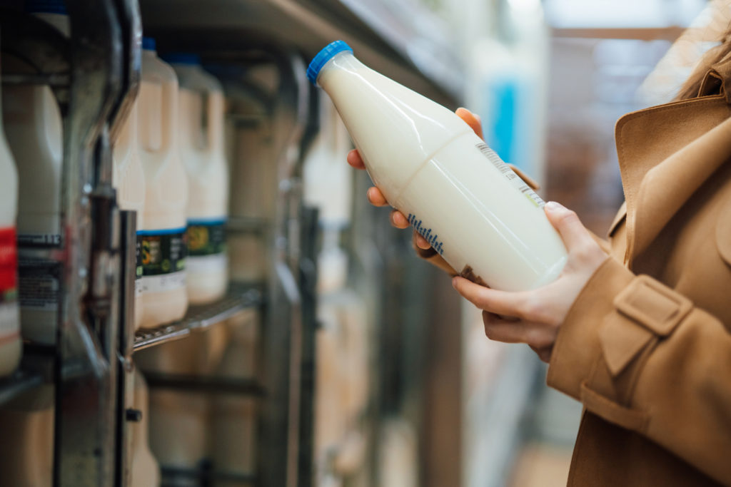 Close up shot of woman holding a bottle of organic unsweetened almond milk in supermarket, London, UK. Photo: Oscar Wong / Getty Images.