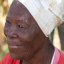 A photo of an older Jamaican woman wearing a headwrap.