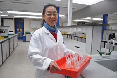 Photograph of Jing Wood in a laboratory. Jing is a Waste and Safety Technician in Chemistry.