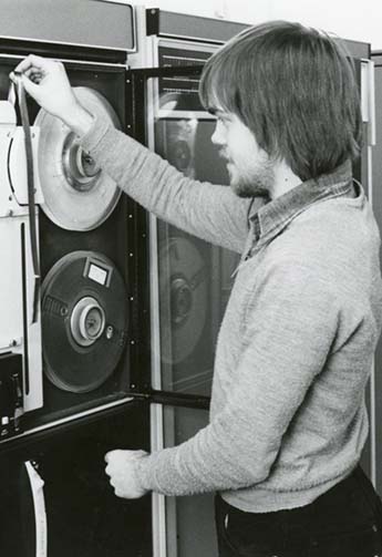 Chris Gowland, member of staff in Computing Service, operating a tape machine, 1980s.