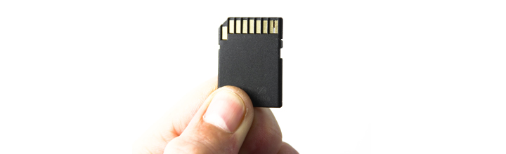 A hand holding a memory card.