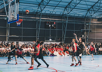 A student scoring a goal in basketball at the opening ceremony of Roses 2017.