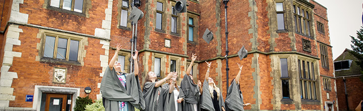 Graduands throwing their mortar boards in the air outside Heslington Hall