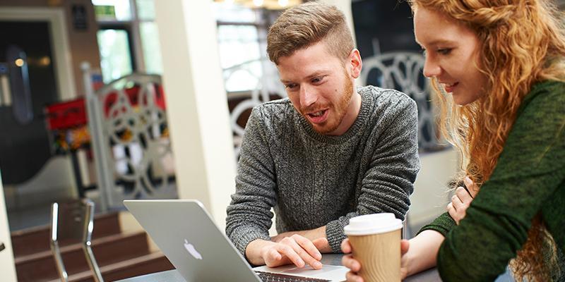 A student looking at his laptop in the Berrick Saul Building.