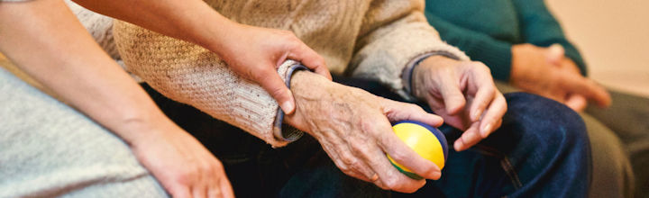 Person holding elderly person's wrist