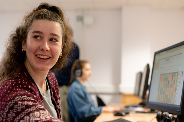 A student discussing their work on the computer