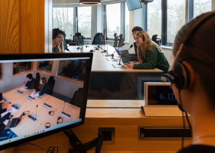 A view from an interpreting booth on an in-person conference taking place.