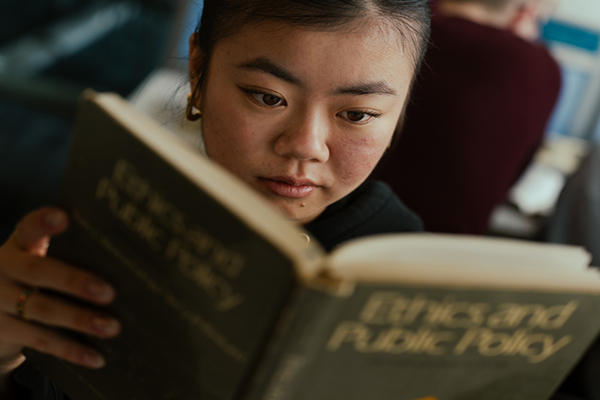 A student reading a book about philosophy
